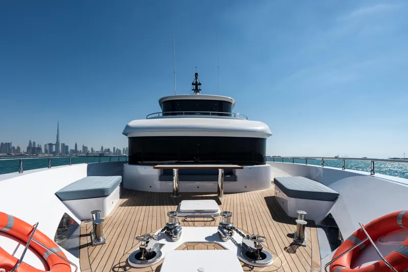 Slide: The Image of Luxurious 2025 Nomad 95 SUV yacht deck with city skyline and clear blue sky. - 20