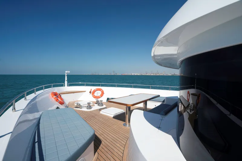 Slide: The Image of Luxurious Nomad 95 SUV yacht deck with seating, table, and ocean view, 2025 model. - 21