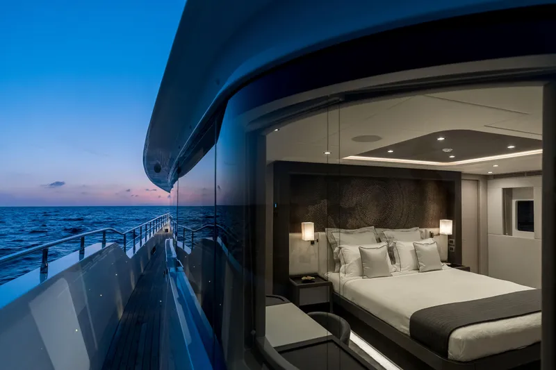 Slide: The Image of Luxurious bedroom view on 2025 Nomad 95 SUV yacht at sunset over the ocean. - 22