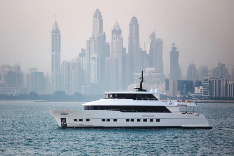 Slide: The Image of Luxury Nomad 95 SUV yacht cruising with city skyline backdrop, 2025 model. - 27