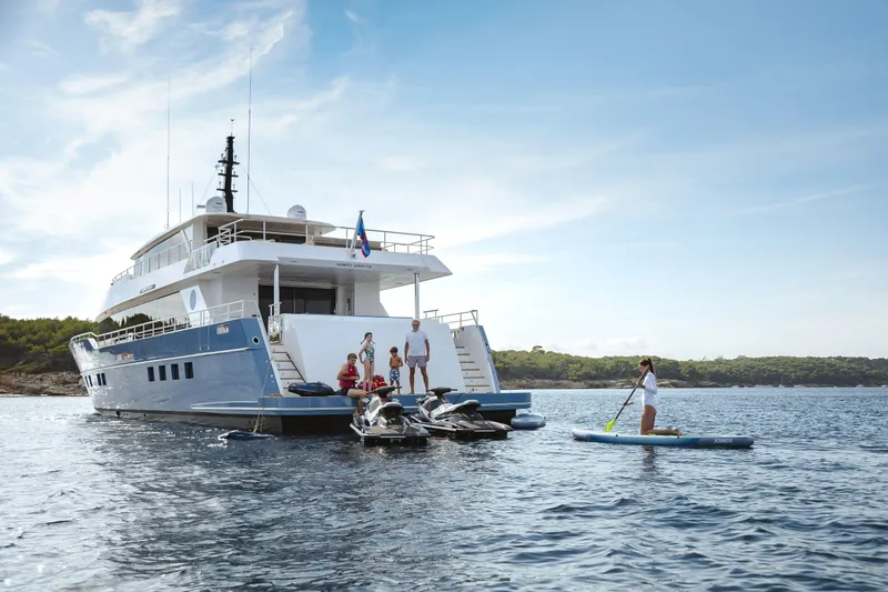 Slide: The Image of Luxury Nomad 95 SUV yacht with people enjoying water activities, 2025 model. - 34