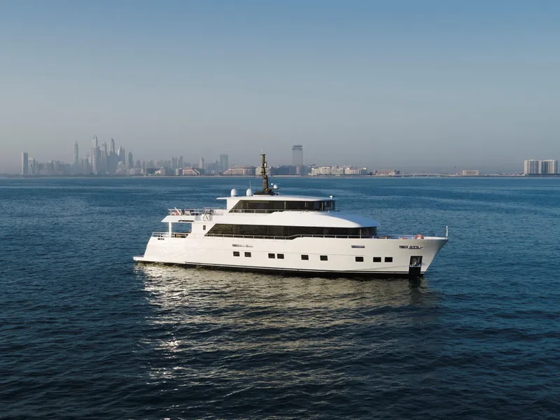 The Image of Luxury Nomad 95 SUV yacht cruising on open water, city skyline in background, 2025 model. - 1