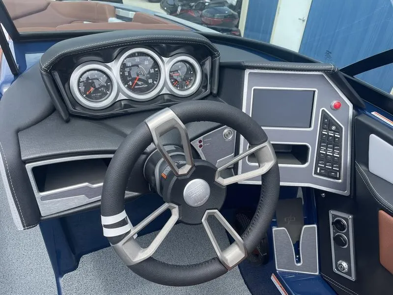 Slide: The Image of 2023 MasterCraft XT24 boat dashboard with steering wheel, gauges, and control panel. - 10