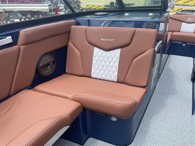 Slide: The Image of 2023 MasterCraft XT24 boat interior with brown leather seats and white accents. - 13