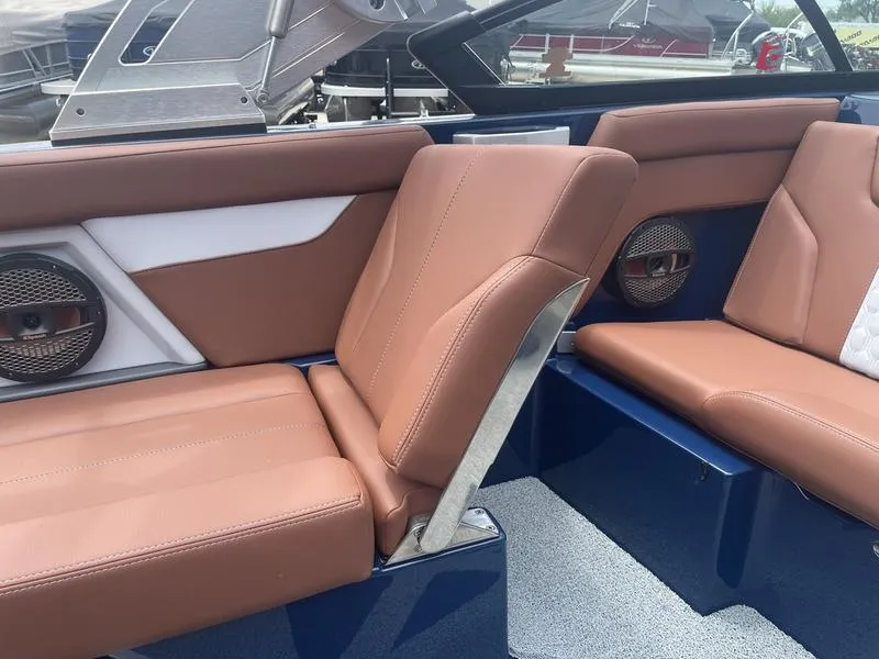 Slide: The Image of 2023 MasterCraft XT24 boat interior with brown leather seats and built-in speakers. - 14