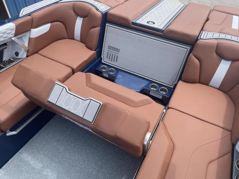 Slide: The Image of 2023 MasterCraft XT24 boat interior with brown leather seating and cup holders. - 15