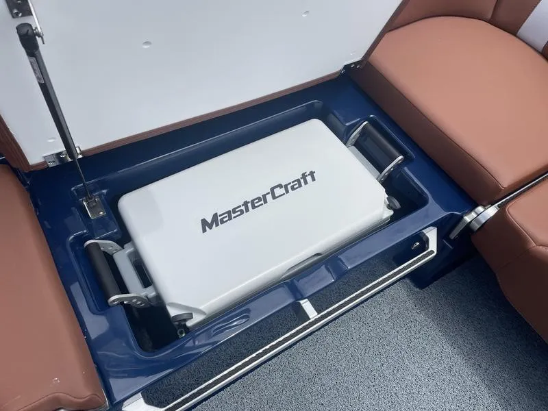 Slide: The Image of 2023 MasterCraft XT24 boat storage compartment with integrated cooler. - 17