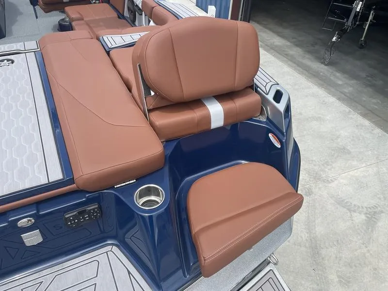 Slide: The Image of 2023 MasterCraft XT24 boat with brown leather seating and blue exterior. - 9
