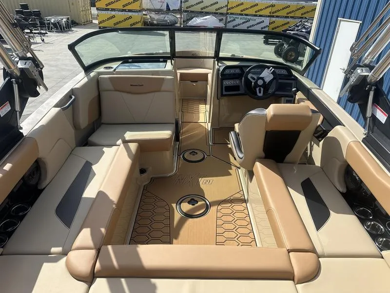 Slide: The Image of 2024 MasterCraft NXT21 boat interior with tan and black seating, modern dashboard, and spacious layout. - 10