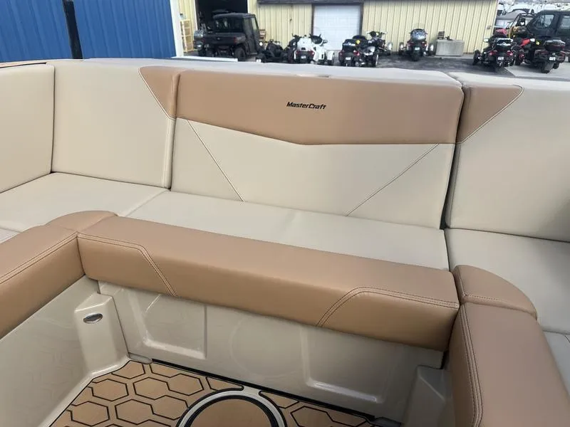 Slide: The Image of 2024 MasterCraft NXT21 boat interior with beige and tan seating. - 18