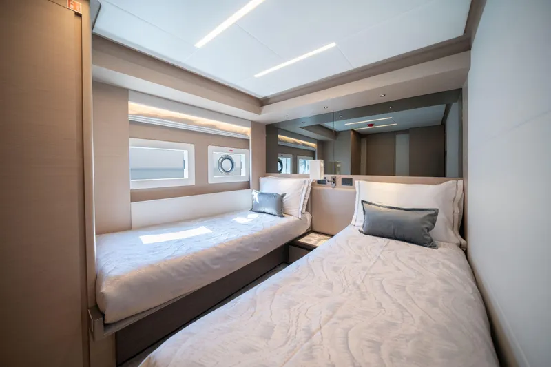 Slide: The Image of Luxurious twin cabin interior of 2025 Nomad 75 SUV yacht, featuring modern design and comfortable bedding. - 15
