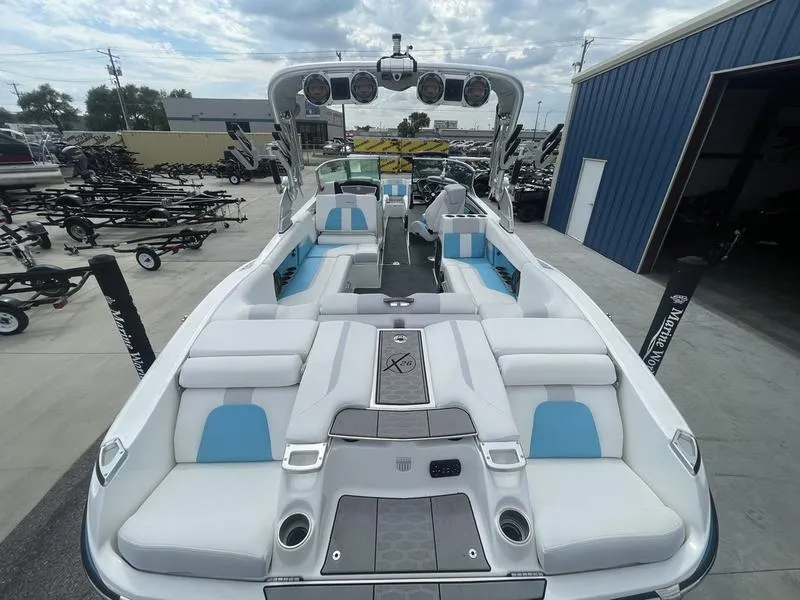 Slide: The Image of 2019 MasterCraft X26 boat with white and blue interior, docked at a marina. - 11