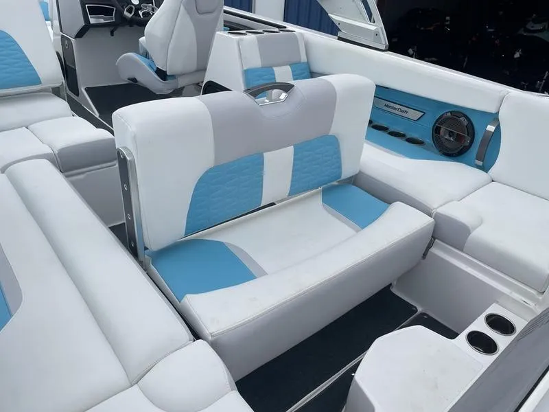 Slide: The Image of 2019 MasterCraft X26 boat interior with white and blue seating. - 14