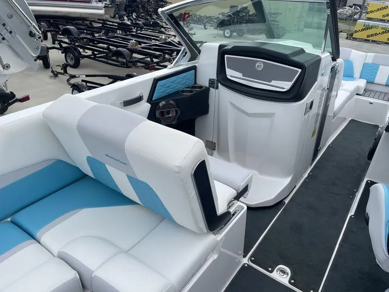 Slide: The Image of 2019 MasterCraft X26 boat interior with white and blue seating, dashboard, and cup holders. - 15
