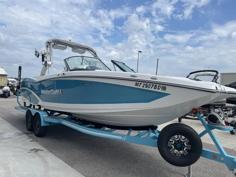 Slide: The Image of 2019 MasterCraft X26 boat on a trailer, blue and white exterior. - 3