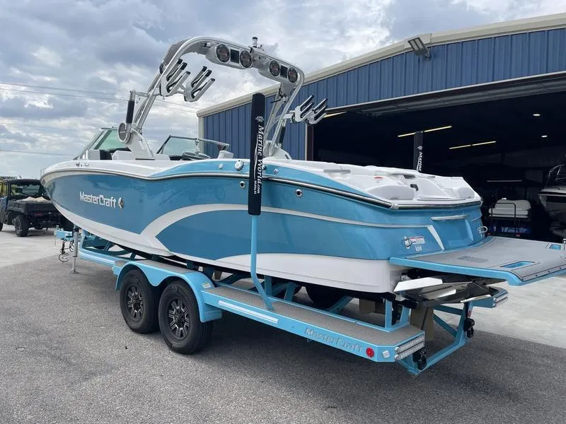 Slide: The Image of 2019 MasterCraft X26 boat on a trailer outside a blue warehouse. - 4