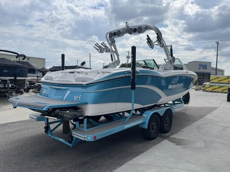 Slide: The Image of 2019 MasterCraft X26 boat on a trailer in a marina. - 6