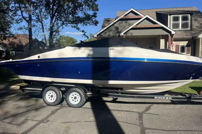 The Image of 2014 Rinker 246 Captiva Bowrider on trailer, parked in residential driveway. - 0