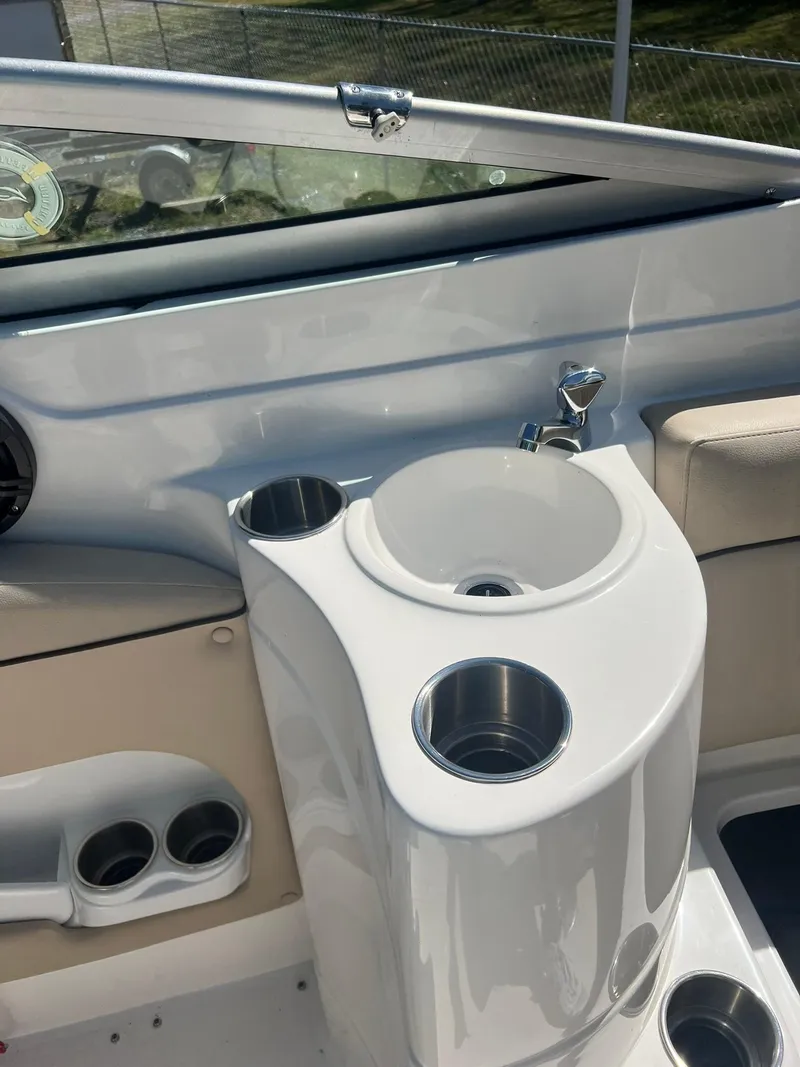 Slide: The Image of 2014 Rinker 246 Captiva Bowrider boat interior with sink and cup holders. - 12