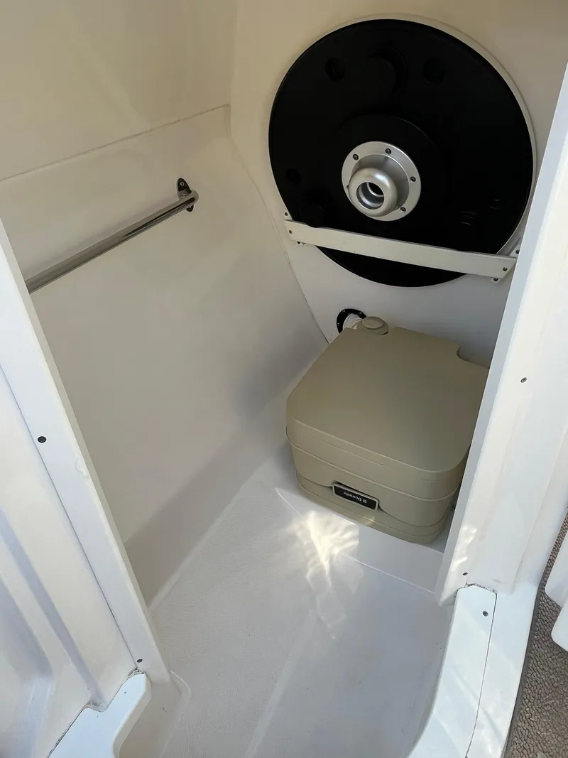 Slide: The Image of 2014 Rinker 246 Captiva Bowrider interior storage compartment with portable toilet. - 15