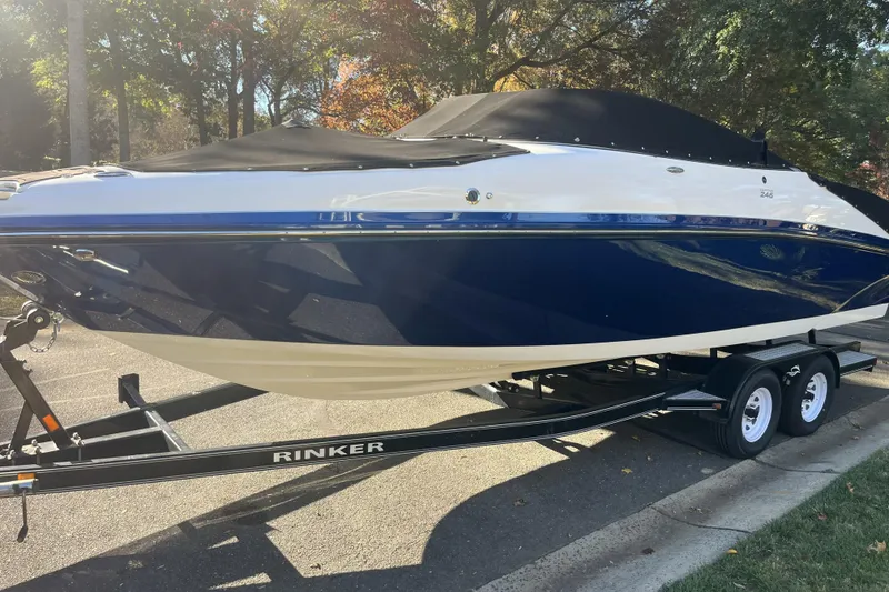 Slide: The Image of 2014 Rinker 246 Captiva Bowrider boat on trailer, parked outdoors. - 2
