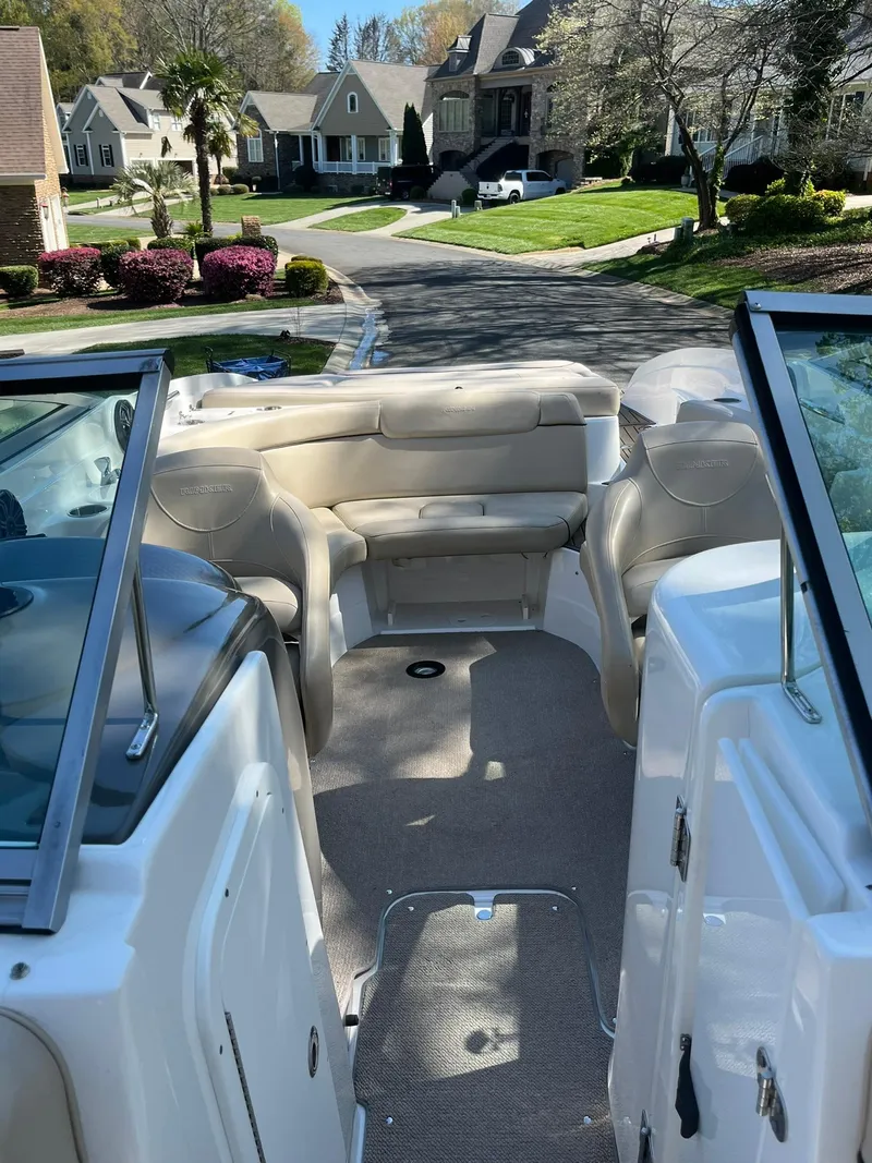 Slide: The Image of 2014 Rinker 246 Captiva Bowrider interior view, parked in a residential neighborhood. - 5