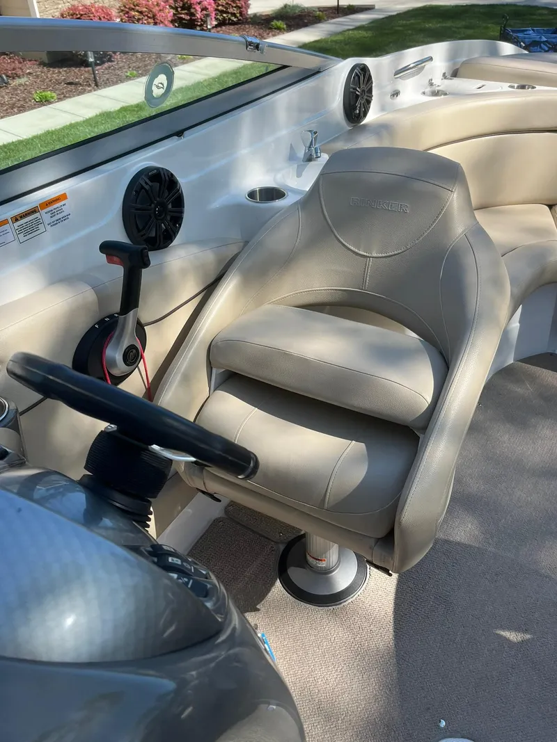 Slide: The Image of 2014 Rinker 246 Captiva Bowrider interior with beige captain's chair and steering wheel. - 8