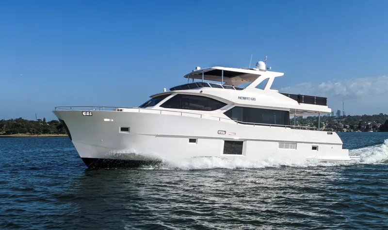 The Image of Luxury Nomad 65 yacht cruising on water, 2025 model, under clear blue sky. - 1