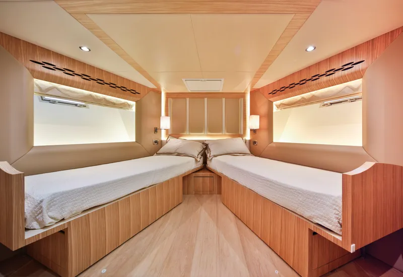 Slide: The Image of Luxurious twin cabin interior in 2025 Nomad 65 yacht, featuring modern wood finishes. - 10