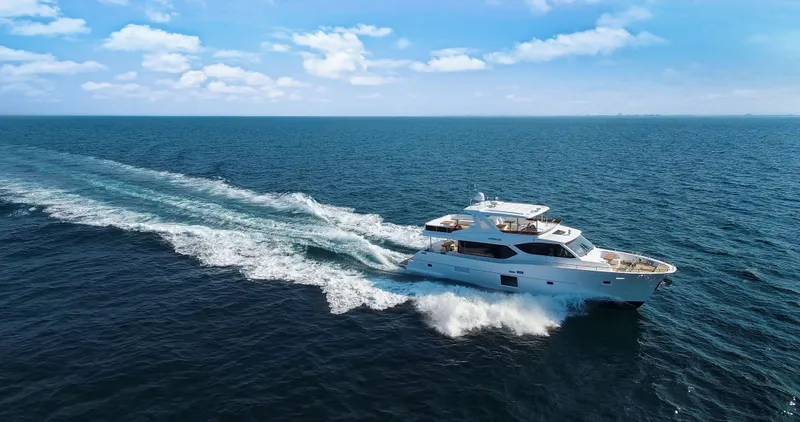 Slide: The Image of Luxury Nomad 65 yacht cruising on open sea under clear blue sky, 2025 model. - 14
