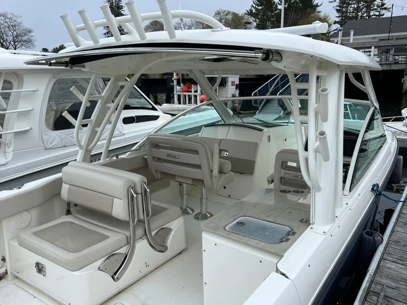 Slide: The Image of 2018 Boston Whaler 320 Vantage boat docked, featuring spacious seating and modern design. - 3