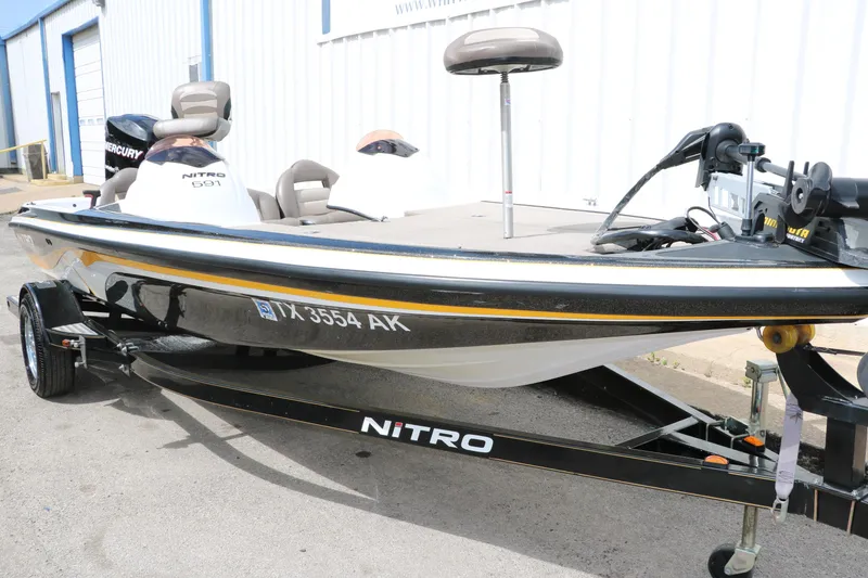 Slide: The Image of 2007 Nitro NX 591 DC fishing boat on trailer, parked outside a building. - 11