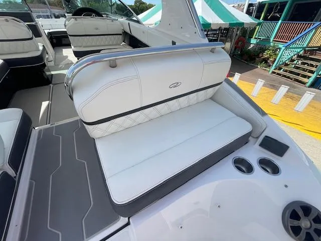 Slide: The Image of 2020 Regal 2800 boat interior with white cushioned seating and cup holders. - 15