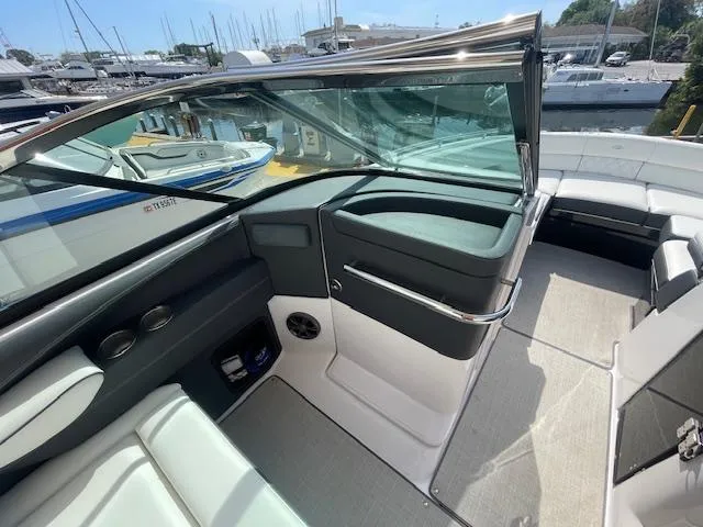 Slide: The Image of 2020 Regal 2800 boat interior with seating and dashboard, docked at marina. - 34