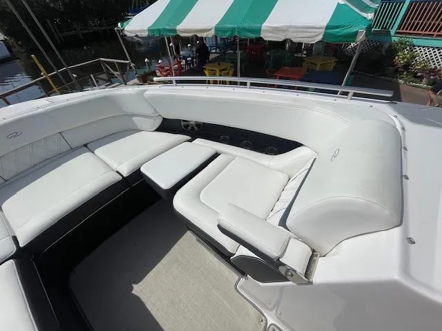 Slide: The Image of 2020 Regal 2800 boat with white leather seating and green-striped canopy. - 37