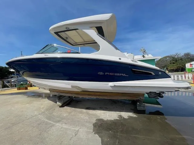Slide: The Image of 2020 Regal 2800 boat on dry dock, blue and white exterior. - 4