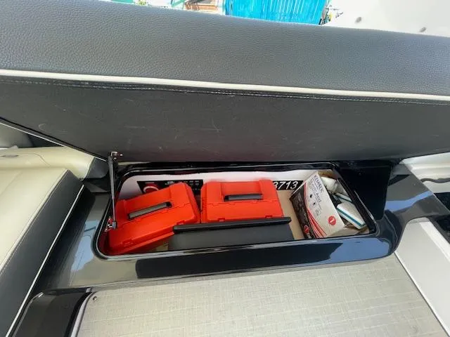 Slide: The Image of Storage compartment in a 2020 Regal 2800 boat with red toolboxes and other items. - 41