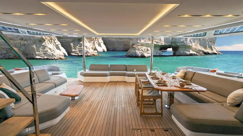 Slide: The Image of Luxurious 2025 Fountaine Pajot Thira 80 yacht interior with elegant seating and dining area, scenic ocean view. - 6