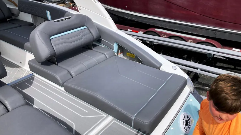 Slide: The Image of 2024 Regal LS9 boat interior with gray seating and a child in an orange shirt. - 13