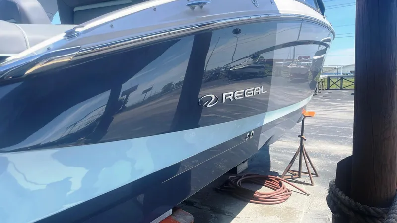 Slide: The Image of 2024 Regal LS9 boat docked, showcasing sleek blue design and branding. - 3