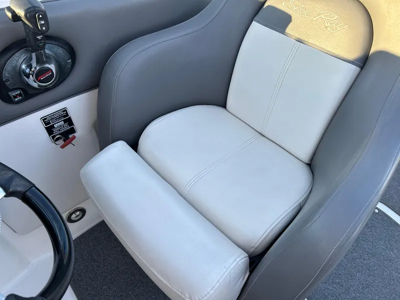 Slide: The Image of Captain's seat of 2011 Sea Ray 300 Sundeck boat, featuring gray and white upholstery. - 12