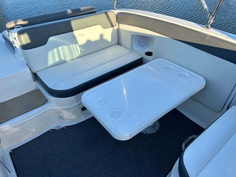 Slide: The Image of 2011 Sea Ray 300 Sundeck interior with seating and table, overlooking water. - 13