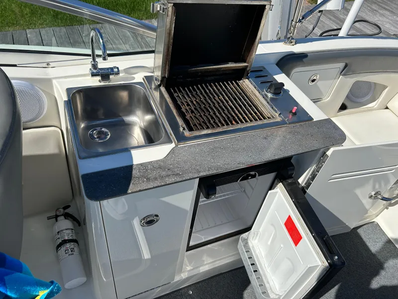 Slide: The Image of 2011 Sea Ray 300 Sundeck boat kitchen with sink, grill, and mini fridge. - 16