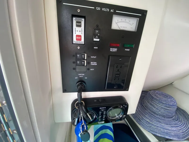 Slide: The Image of Control panel of a 2011 Sea Ray 300 Sundeck boat with keys and a hat nearby. - 18