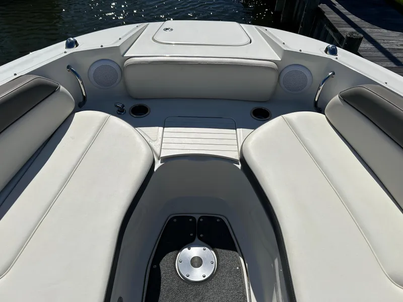 Slide: The Image of 2011 Sea Ray 300 Sundeck interior with white seating and speakers, docked by the water. - 32