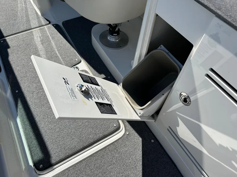 Slide: The Image of 2011 Sea Ray 300 Sundeck interior with open storage compartment and trash bin. - 35
