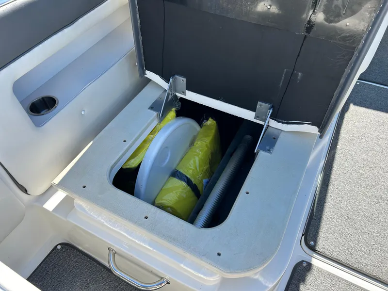 Slide: The Image of Open storage compartment on 2011 Sea Ray 300 Sundeck boat, showing life jackets and equipment. - 37