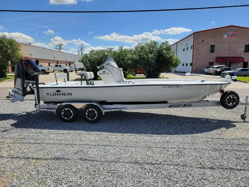 Slide: The Image of 2022 Turner Boatworks 2500 VS on trailer, parked outdoors. - 2
