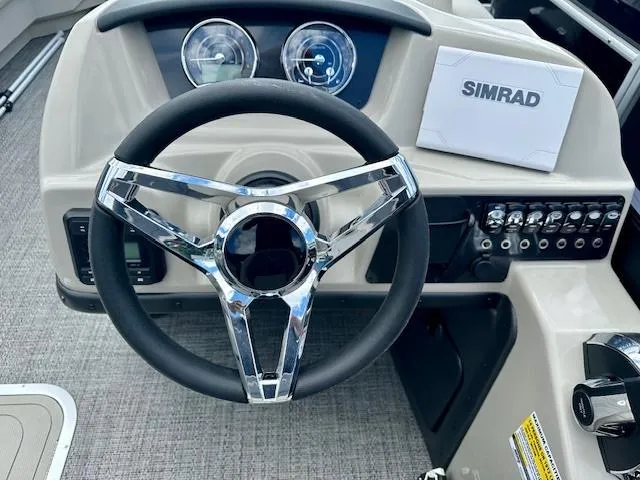 Slide: The Image of 2024 Barletta Aria 24QC boat steering wheel and dashboard with Simrad electronics. - 8