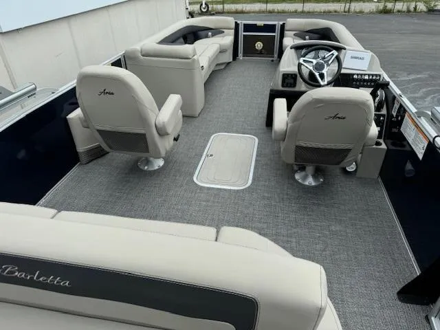 Slide: The Image of 2024 Barletta Aria 24UC pontoon boat interior with beige seating and modern helm. - 2